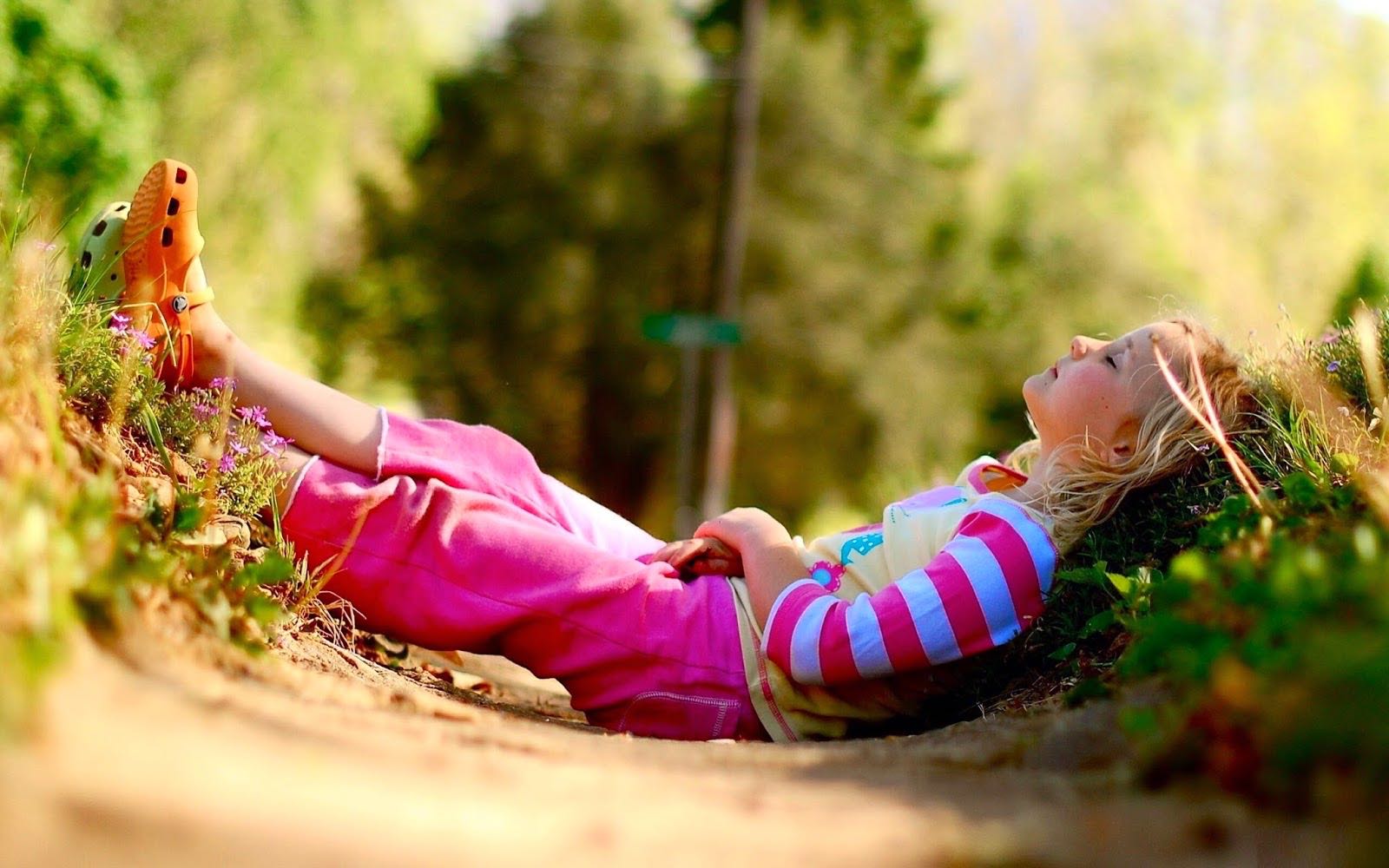 Детская радость лежа на траве бесплатно